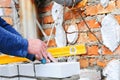 A closeup of a bricklayer worker installing wite blocks and caulking brick masonry joints exterior wall with trowel putty knife ou Royalty Free Stock Photo