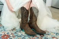Closeup of a bride in cool cowboy boots, the concept of rustic wedding