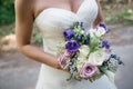 Closeup of a bride holding a bouquet of white, violet and pink roses Royalty Free Stock Photo