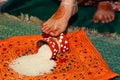 Bride kicking a rice filled pot in griha pravesh ceremony