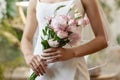 Closeup of bride wearing wedding dress and holding delicate flower bouquet Royalty Free Stock Photo