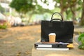 Closeup of briefcase, takeaway coffee cup and document on concrete bench. City life concept Royalty Free Stock Photo