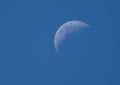 Closeup of bright quarter moon during daytime in blue sky, Semien Mountains Ethiopia Royalty Free Stock Photo