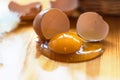 Closeup of broken egg on the kitchen table, basket defocuses. Gr