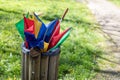 Closeup of a broken multicolor umbrella thrown in a trash can