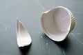 Closeup of broken white ceramic baking bowl with fragments on black marble floor