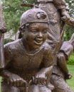 Closeup of a bronze sculpture of children on pogo sticks by Gary Price at the Dallas Arboretum and Botanical Garden