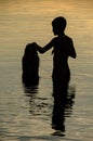 Closeup of brothers in the water of a lake at sunset Royalty Free Stock Photo