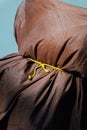 Closeup of a brown coating tied with a yellow knot.