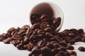 Closeup of brown coffee beans falling out of a cup isolated on a white background Royalty Free Stock Photo