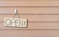 Closeup brown hard paper signboard with open massage on beown wood wall textured background with copy space