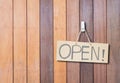 Closeup brown hard paper signboard with open massage on brown wood wall textured background with copy space