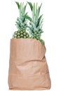 Closeup of a brown paper shopping bag with fresh ripe pineapple fruits isolated on a white background. Concept of strengthening Royalty Free Stock Photo