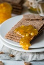 Closeup of brown rye crisp bread Swedish crackers with spread orange jam