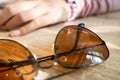 Closeup of brown sunglasses on the table belonging to teen girl. Juvenile fashion lifestyle