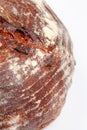 Closeup of browned crust of wheat loaf of bread on white background Royalty Free Stock Photo