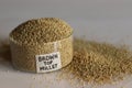 Closeup of browntop millet grains in a pristine glass bowl with label on it filled to the brim