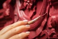 Closeup of brush in female hand slowly painting extraordinary carved ornaments on wooden cupboard in red color. Home