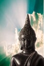 Closeup Buddha statue with dramatic sky background.