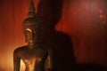 Closeup Buddha statue with warm light. Buddha statue with wood background Royalty Free Stock Photo