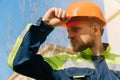 Closeup of a builder engineer holding a helmet with his hand. A man wants to take off his special helmet Royalty Free Stock Photo