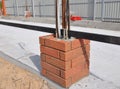 Closeup on Building New Fence Column with Bricklaying, Light Wires and Iron Bar. Royalty Free Stock Photo