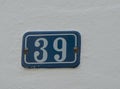 Closeup of the building number on the white wall. Royalty Free Stock Photo