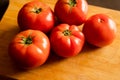 closeup of a bunch of red tomatoes on a wooden board at kitchen table Royalty Free Stock Photo