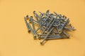 Closeup of a bunch of screws and bolts on a yellow background Royalty Free Stock Photo