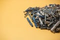 Closeup of a bunch of screws and bolts on a yellow background Royalty Free Stock Photo