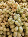 Closeup of bunches of green grapes on market stall.