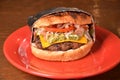 Closeup of a burger wrapped in foil on a red plate in a fast food restaurant