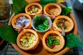 Burmese Tea Leaf Salad or Lahpet in a wooden plate with Wild Betel Leaves on a light wooden table in warm tone Royalty Free Stock Photo