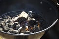 Closeup of burning coals and wood on a grill grate