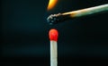 Closeup of burning match with red sulfur head on dark background Royalty Free Stock Photo