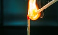 Closeup of burning match with red sulfur head on dark background Royalty Free Stock Photo