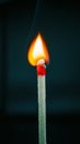 Closeup of burning match with red sulfur head on dark background Royalty Free Stock Photo