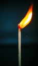 Closeup of burning match with red sulfur head on dark background Royalty Free Stock Photo