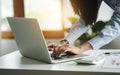 Closeup of business female hands busy typing on a laptop with calculator in office Royalty Free Stock Photo