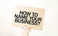 Closeup Business man hand holding show blank paper sheet HOW TO NAME YOUR BUISINESS