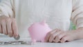 closeup of business man hand putting money coin into piggy bank for saving money. wealth, Finance, business, investment,