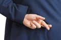 Closeup of a business man with his hands behind his back and fingers crossed. Royalty Free Stock Photo