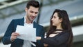 Closeup business partners reading documents. Couple discussing project outside