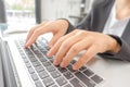 Closeup of business woman hand typing on laptop keyboard .