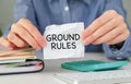 Closeup on business woman holding a card with text GROUND RULES, business concept image with soft focus background and vintage