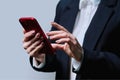 Closeup of business woman's hands using smartphone, on gray background Royalty Free Stock Photo