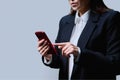 Closeup of business woman's hands using smartphone, on gray background Royalty Free Stock Photo