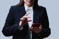 Closeup of business woman& x27;s hands using smartphone, on gray background Royalty Free Stock Photo