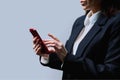 Closeup of business woman's hands using smartphone, on gray background Royalty Free Stock Photo