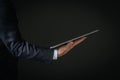 Closeup of businessman hand holding a modern digital notepad isolated on a dark background Royalty Free Stock Photo
